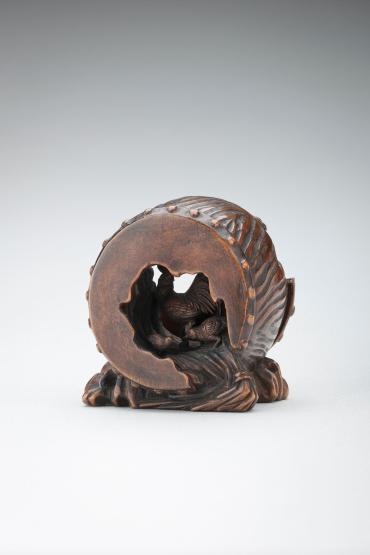 Netsuke: rooster, hen and chicken inside a broken war drum