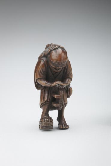 Netsuke: old man with broken geta