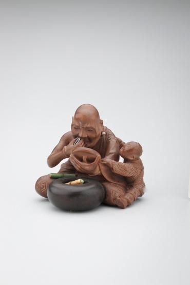 Netsuke: priest with mirror attended by small boy