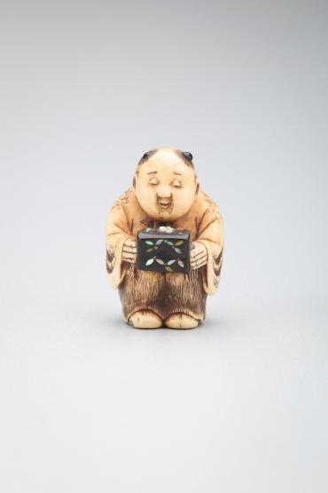 Netsuke: Chinese boy holding a wooden box