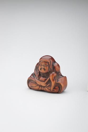 Netsuke: Daruma seated and holding a fly-whisk