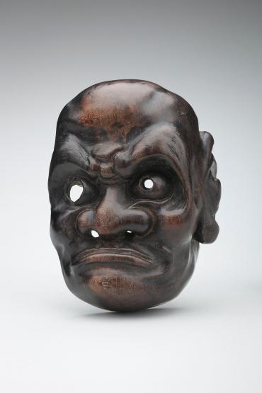 Netsuke: mask of a man with a fly-whisk for its eyebrows