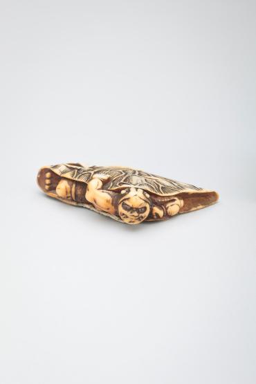 Netsuke: demon caught in a lotus leaf