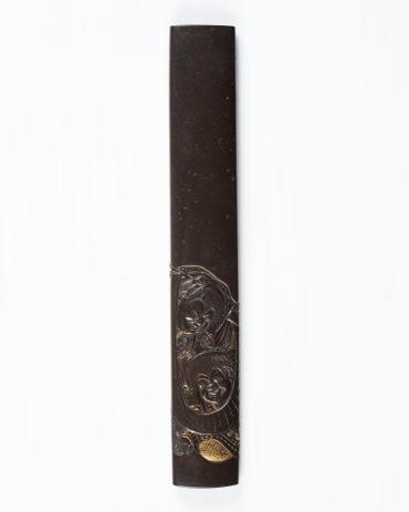 Kozuka: (front) Engraved Heads of Two Happy Boys; (back) inscription on textured ground