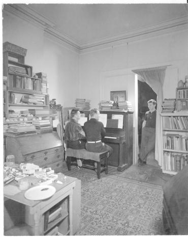 Untitled (Paul Cadmus and Jared French (seated at the piano) with George Tooker standing in the doorway), from a collection of 33 photographs of members of Lincoln Kirstein's circle