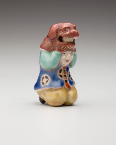 Netsuke: Shishimai child dancer lifting a lion mask (red mask)