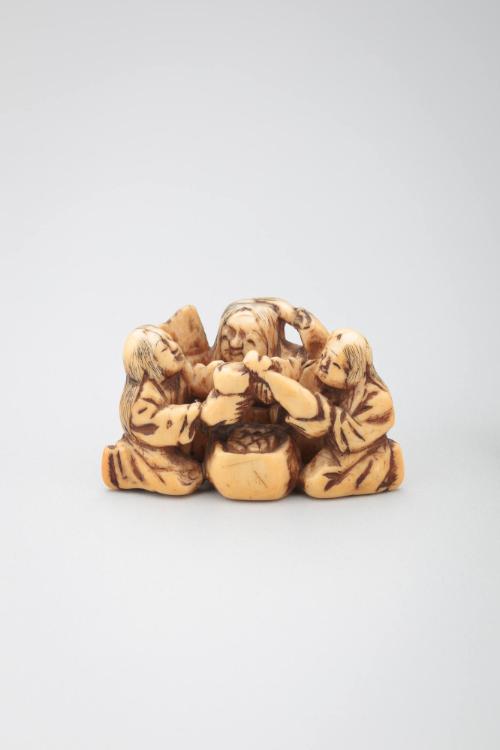 Netsuke:  three figures around a Brazier