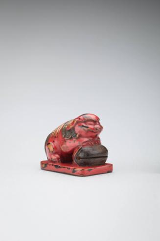 Netsuke:  lion-dog resting on a wooden gong