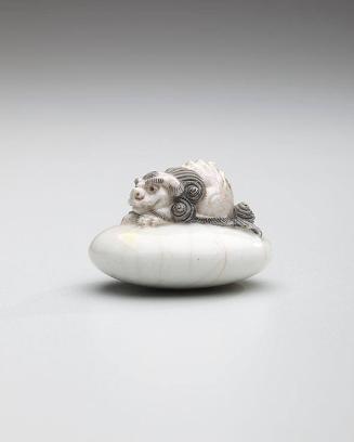 Netsuke: Shishi lion recumbent on a pillow